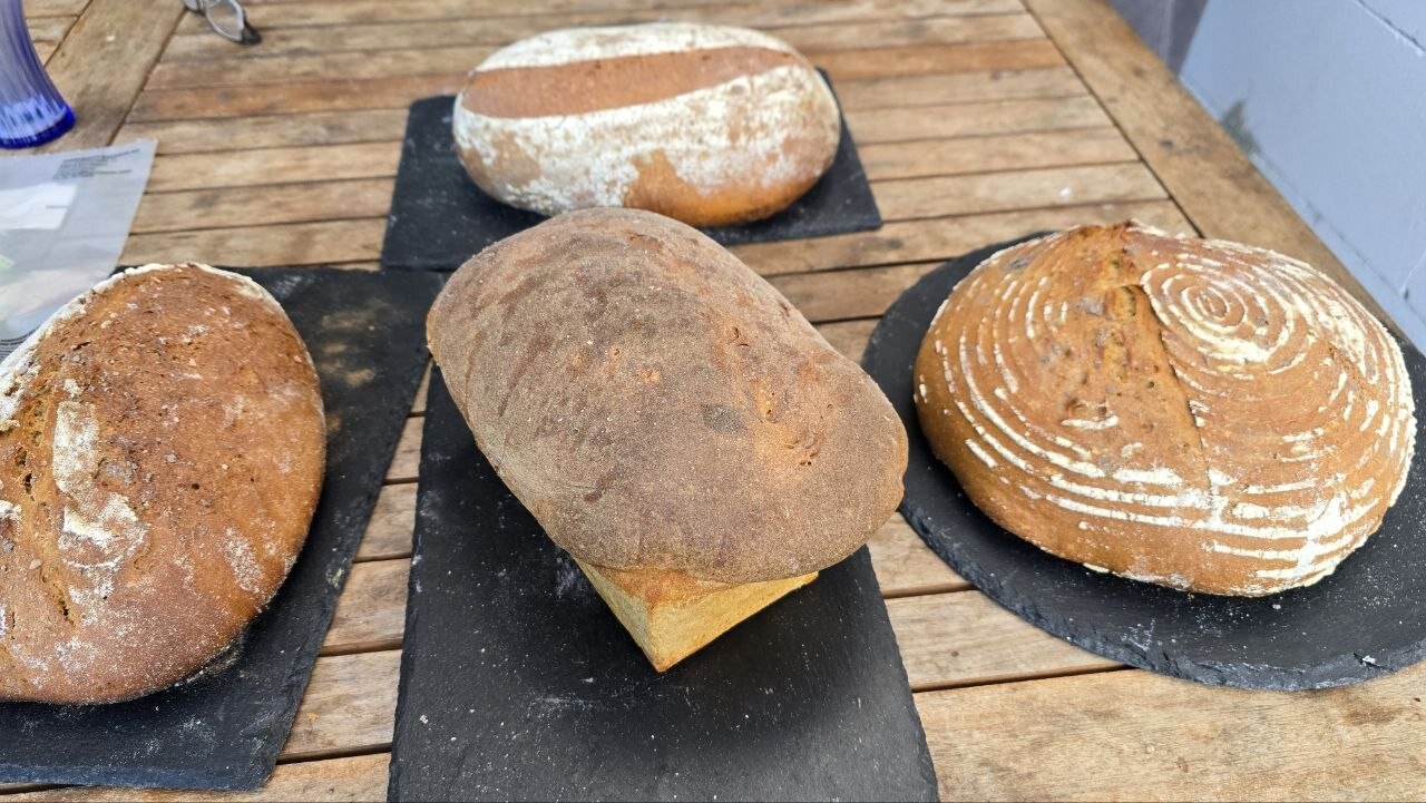 Four finished loaves on slate boards